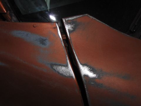 1980 Chevrolet Camaro - The gap between two car body panels reveals exposed metal and primer, indicating bodywork in progress.