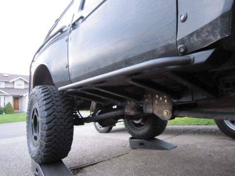 1996 Ford Bronco - Undercarriage view of a 1996 Ford Bronco with aftermarket rock sliders and lifted suspension.