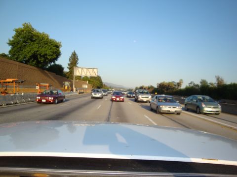 1995 Ford Taurus - Driving on a highway with multiple cars and construction zone visible under a clear blue sky.