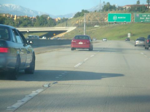 1995 Ford Taurus - Multiple vehicles on a highway under a clear sky.