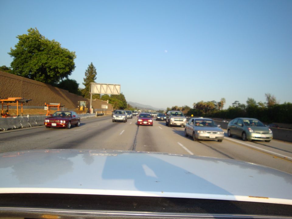 Highway traffic scene with multiple cars under a clear blue sky
