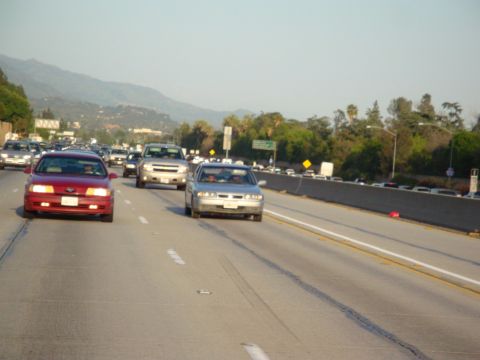 1995 Ford Taurus - A busy highway scene with multiple vehicles moving along the road under a clear sky.