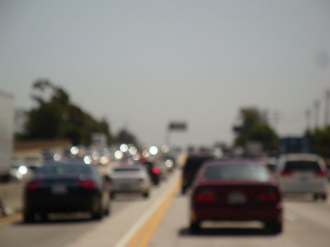 1995 Ford Taurus - A highway scene with multiple vehicles in traffic under a bright, hazy sky.