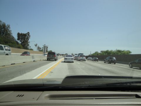 1995 Ford Taurus - A white 1995 Ford Taurus sedan is seen from the rear traveling on a multi-lane highway.