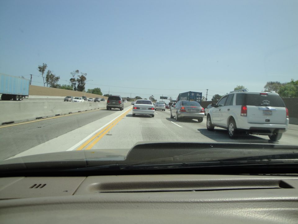 Highway traffic with multiple cars and trucks under a clear blue sky