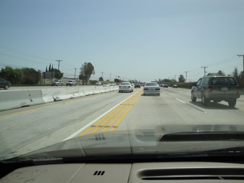 1995 Ford Taurus - The view from inside a vehicle driving on a multi-lane highway under a clear blue sky.
