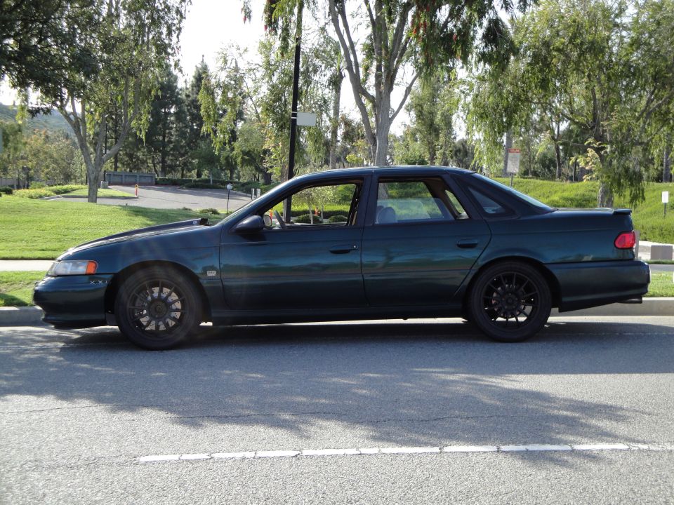 Dark green 1995 Ford Taurus sedan, side view
