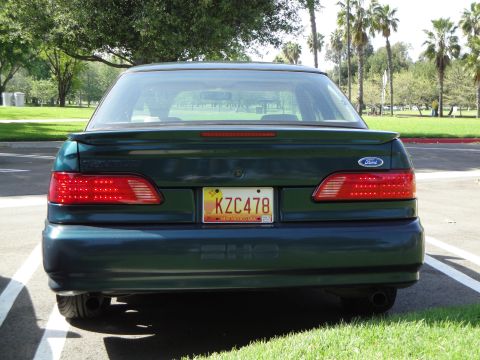 1995 Ford Taurus - Rear view of a 1995 Ford Taurus sedan, showing its taillights and license plate.
