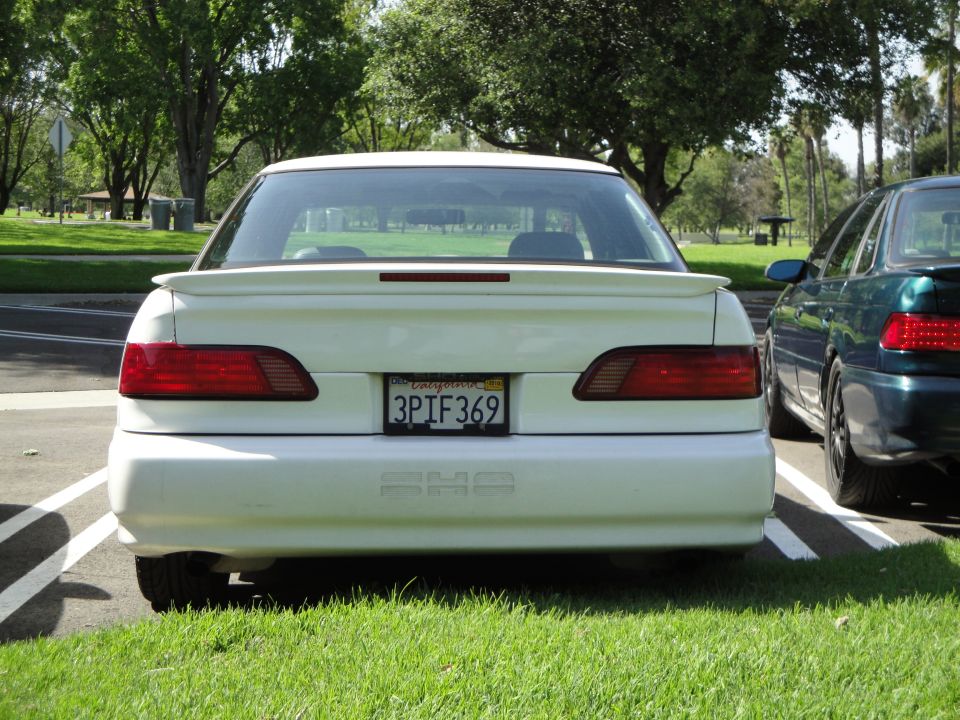 1995 Ford Taurus SHO rear view with California license plate 3PIF369. Another car is parked to the right