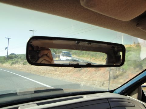 1995 Ford Taurus - A white van is visible in the rearview mirror as the camera car drives on a highway.