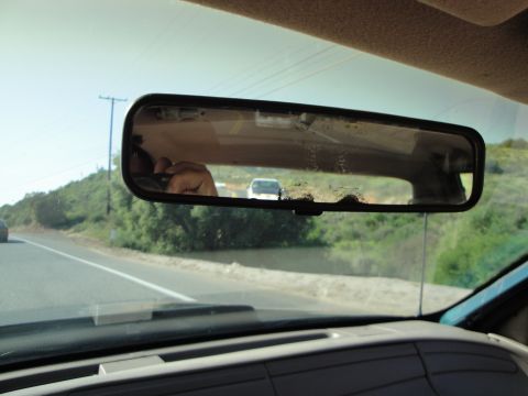1995 Ford Taurus - Looking through the rearview mirror at another car on the road ahead.