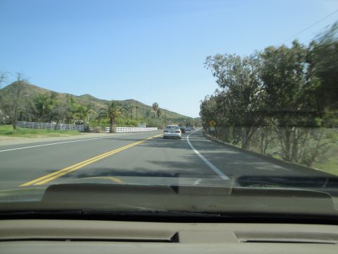 1995 Ford Taurus - A view from inside a car driving on a sunny day, with other vehicles on the road ahead.