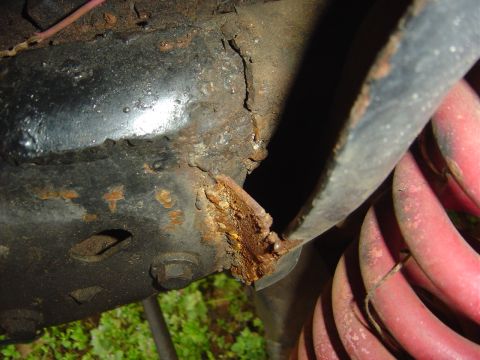 1986 Ford Bronco - Rusted frame and suspension part, likely from an older vehicle.