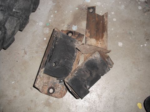 1991 Ford Bronco - Several used engine mounts are shown scattered on a concrete floor.