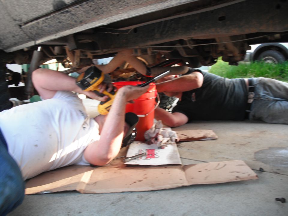 People working under a vehicle's chassis