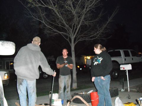 1991 Ford Bronco - A group of people are gathered outdoors at night, with a white pickup truck visible in the background.