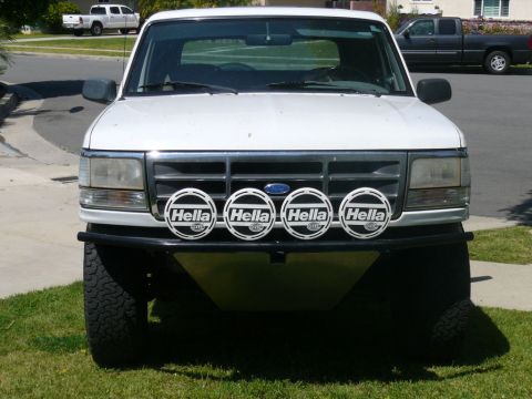 1988 Ford Bronco - Front view of a white Ford Bronco, likely a 1992-1996 model, with aftermarket lights and bumper.