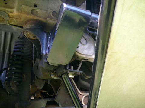 1988 Ford Bronco - Close-up view of the undercarriage of a vehicle, highlighting suspension parts and an aftermarket bracket.