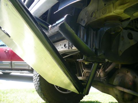 1988 Ford Bronco - Close-up of vehicle undercarriage modifications, with another vehicle visible in the background.