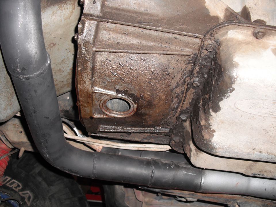 Transmission housing and black exhaust pipe on a vehicle underside