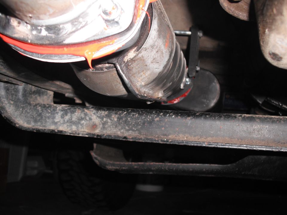 close-up of a vehicle's exhaust pipe connection with sealant