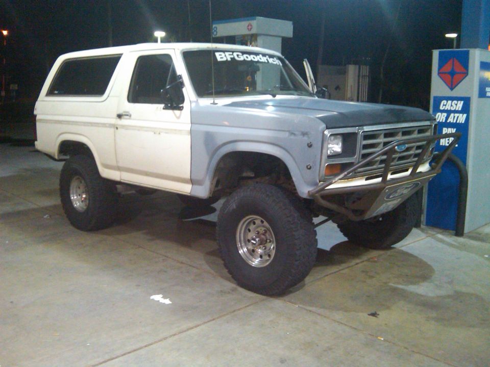 Lifted Ford Bronco with primer gray fender and hood, BFGoodrich sticker on windshield