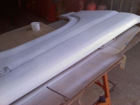 1986 Ford Bronco - A white fender part is shown resting on a table, possibly awaiting repair or painting.