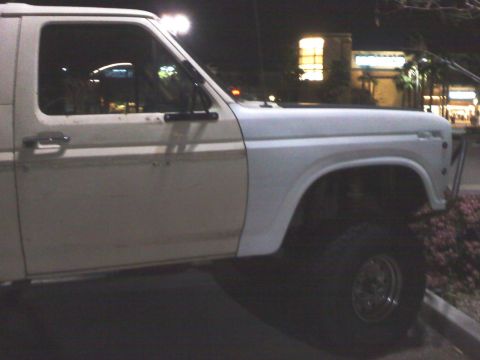 1986 Ford Bronco - Side view of a white Ford Bronco, likely from the early 1980s.