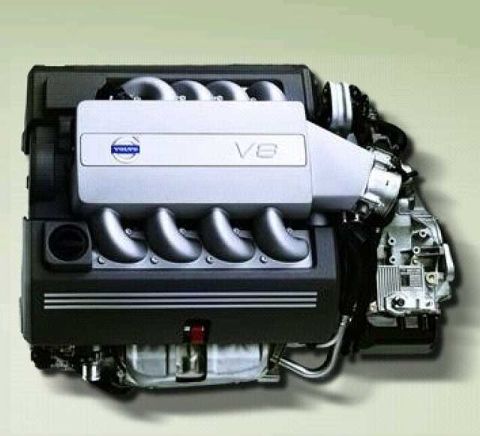1997 Ford Taurus - A Volvo V8 engine photographed from above against a plain light background, showing the silver plastic engine cover with the Volvo logo and…