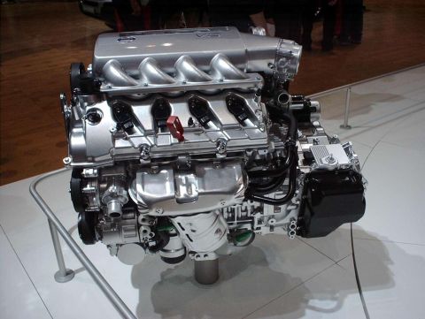 1997 Ford Taurus - A cutaway-clean V8 engine on a white display stand at an auto show, shown from the front with a polished aluminum intake manifold, long tub…