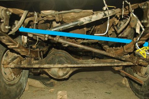 1987 Suzuki Samurai - Close-up of the rear axle and leaf spring suspension system of a vehicle.