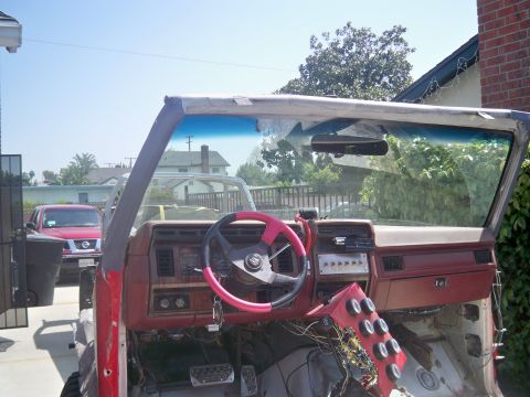 1985 Ford Bronco - The interior of a vehicle is shown with the dashboard partially disassembled and wiring exposed.