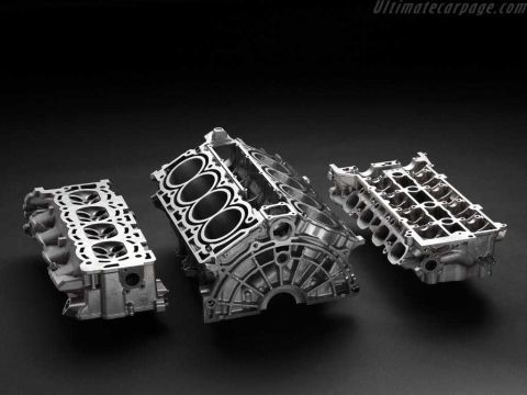 1997 Ford Taurus - Disassembled aluminum V8 engine components shown against a dark studio background, including the cylinder block with visible cylinder bores…
