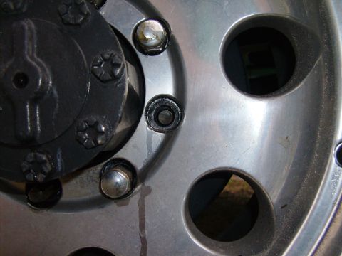 1995 Ford Bronco - Detail of a wheel hub assembly, showing lug nuts and the center cap.