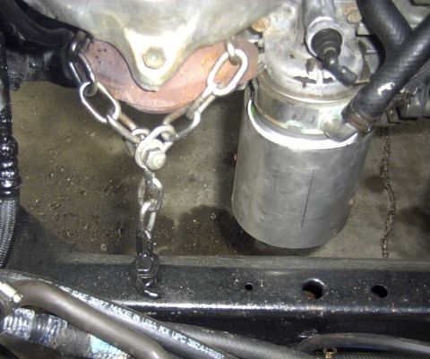 1997 Ford Taurus - Close-up view of an engine component secured with a metal chain.