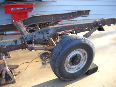 1954 Ford F-100 - The chassis of a truck, likely undergoing restoration, is visible with its suspension components.