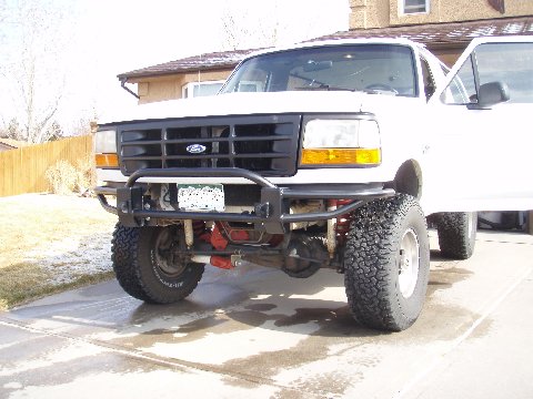 1993 Ford Bronco - Front view of a white 1993 Ford Bronco, an aftermarket bumper and winch, parked on a driveway.