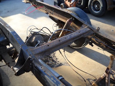 1954 Ford F-100 - The chassis of a truck is shown on jack stands, revealing the rear axle and suspension components.