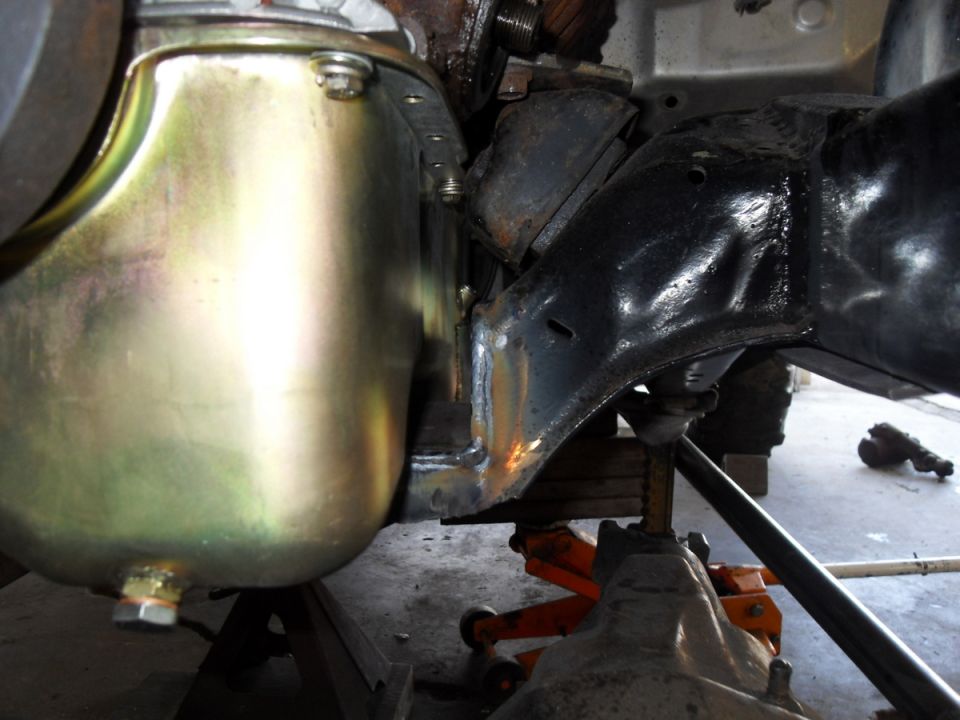Vehicle frame and yellow oil pan supported by jack stands