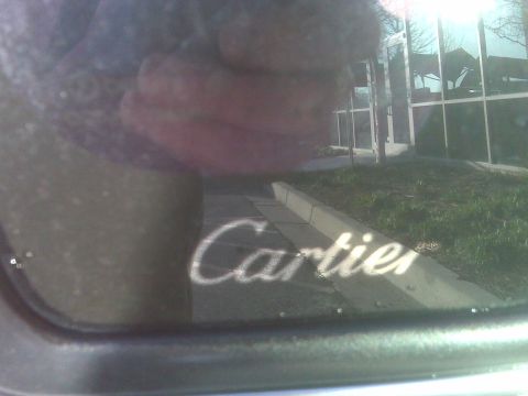 1993 Lincoln Town Car - Reflection of Cartier text on a car window, Supermotors.net logo visible at bottom right.