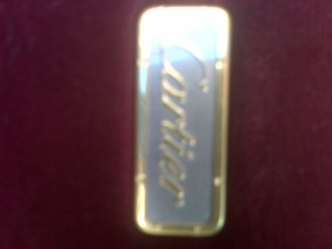 1993 Lincoln Town Car - A close-up of a Cartier lighter with gold trim and a blue insert.