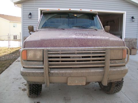 1988 Ford F-150 - Muddy 1987 Ford F-150 pickup truck parked in front of a garage.