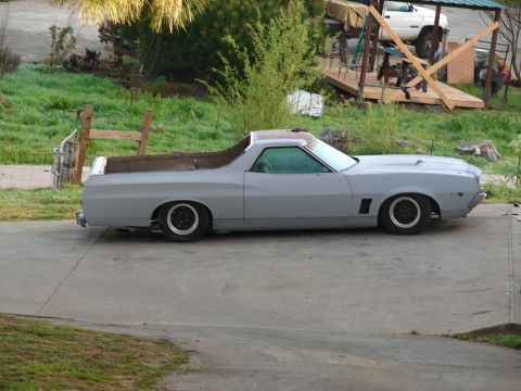 1973 Ford Ranchero - Side profile of a gray 1973 Ford Ranchero pickup, unfinished primer coat, with a lowered stance.