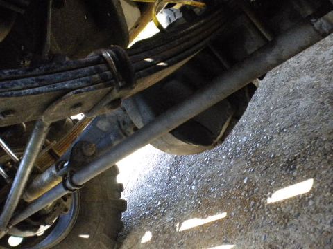 1989 Ford Bronco - Close-up view of the suspension and steering components, showing leaf springs and tie rods.