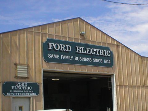 1978 Ford Bronco - Exterior of a commercial building with "Ford Electric" signage and a "Customer Service Entrance" sign.