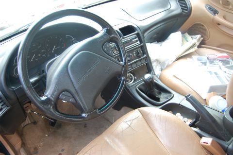 1996 Ford Probe - The interior of a 1996 Ford Probe, a manual transmission and worn leather seats.