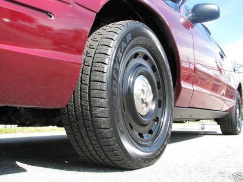 2005 Ford Crown Victoria - Side view of a red 2005 Ford Crown Victoria, steel wheels and Goodyear tires.