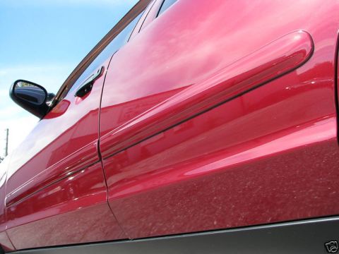 2005 Ford Crown Victoria - Side view of a red 2005 Ford Crown Victoria showing the door and lower body molding.