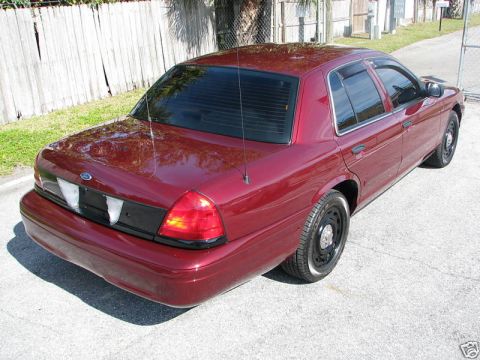 2005 Ford Crown Victoria - This maroon Ford Crown Victoria is shown from the rear, with a blacked-out panel between the taillights.