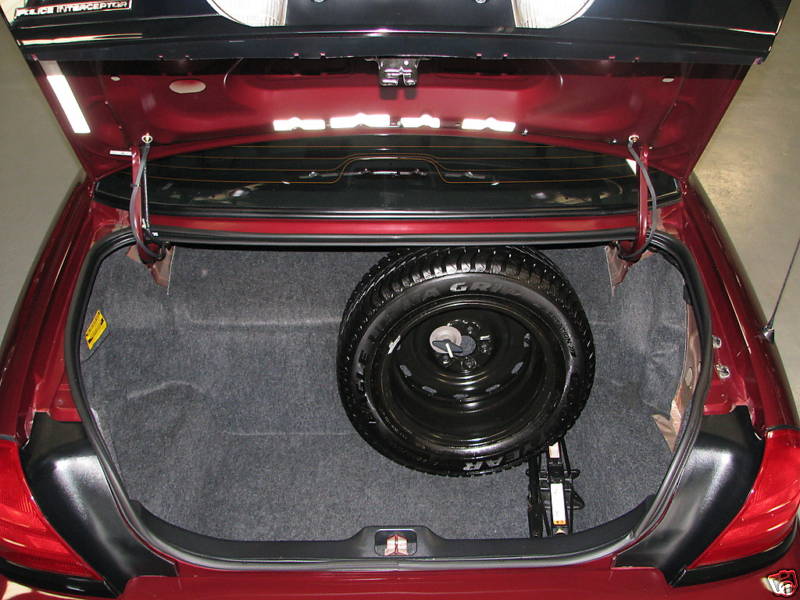 Trunk of a 2005 Ford Crown Victoria showing spare tire and jack